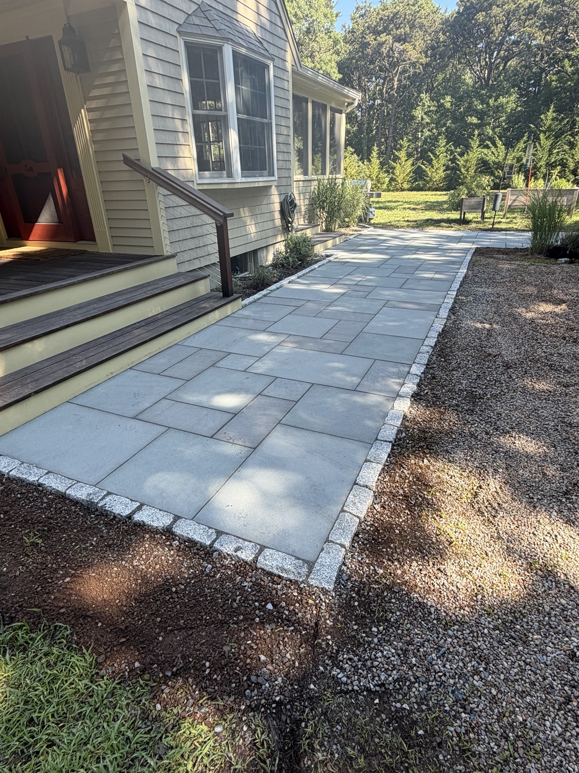 Bluestone-look paver walkway with cobblestone edging